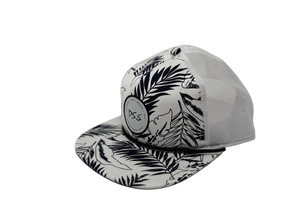 Black and white cap with leaf pattern on a light gray background