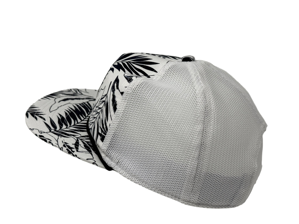 White cap with black leaf pattern on visor against a gray background