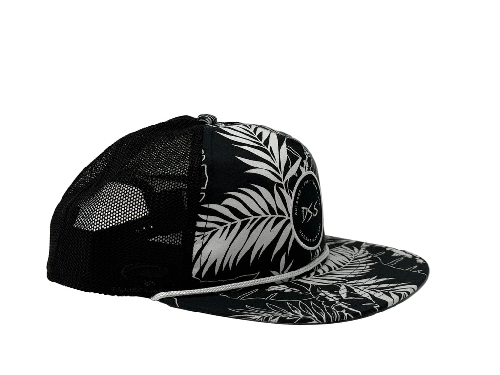 Black and white cap with leaf pattern on a light gray background
