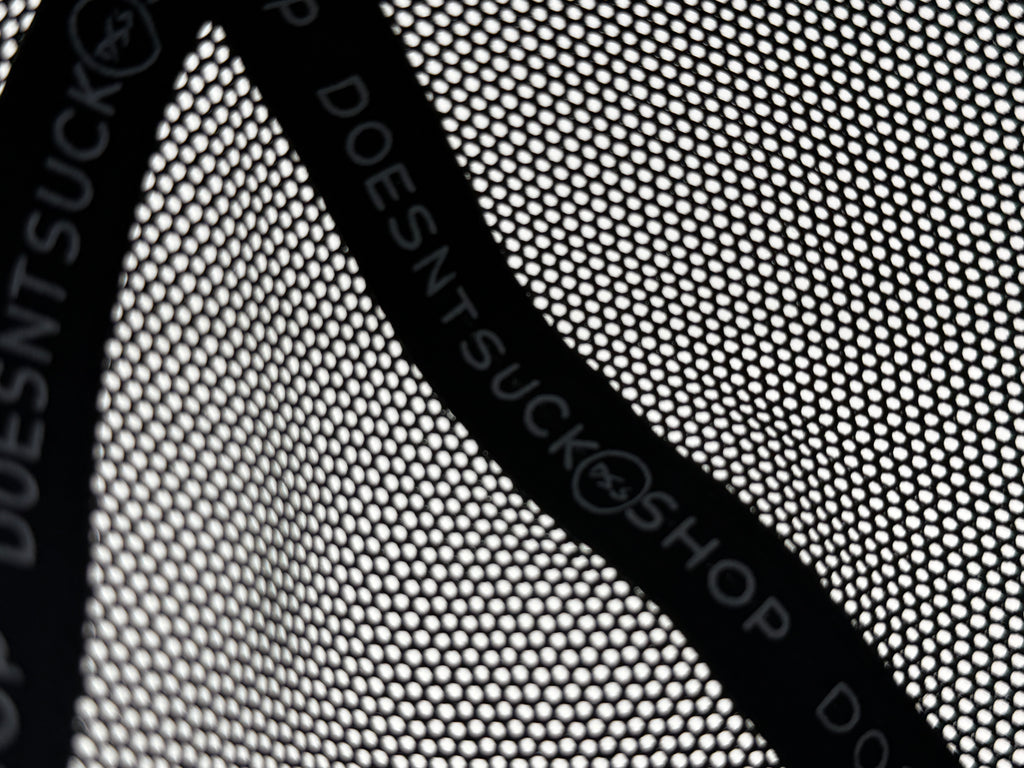Black mesh with 'DOESNT SUCK' text on a white background