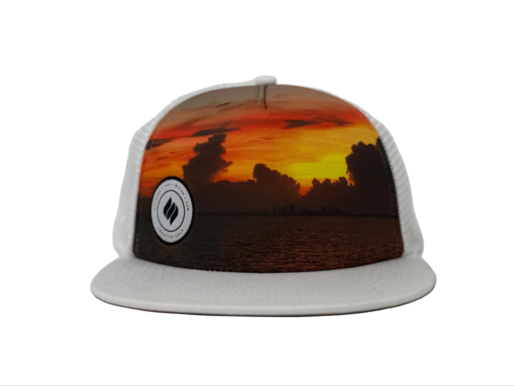 Trucker hat with sunset design and logo on a gray background