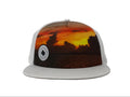 Trucker hat with sunset design and logo on a gray background
