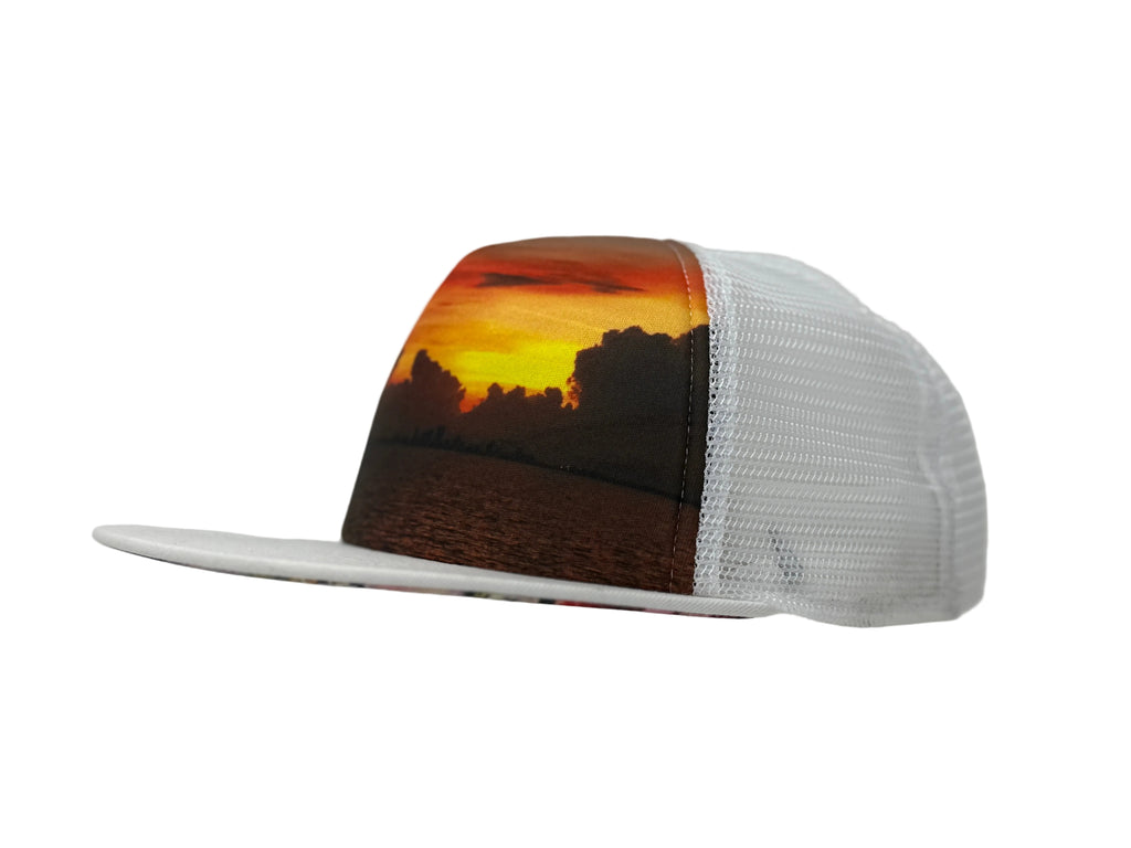 Trucker hat with a sunset and landscape design on a mannequin head against a white background