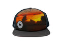 Charcoal Trucker hat with sunset design and logo on a white background