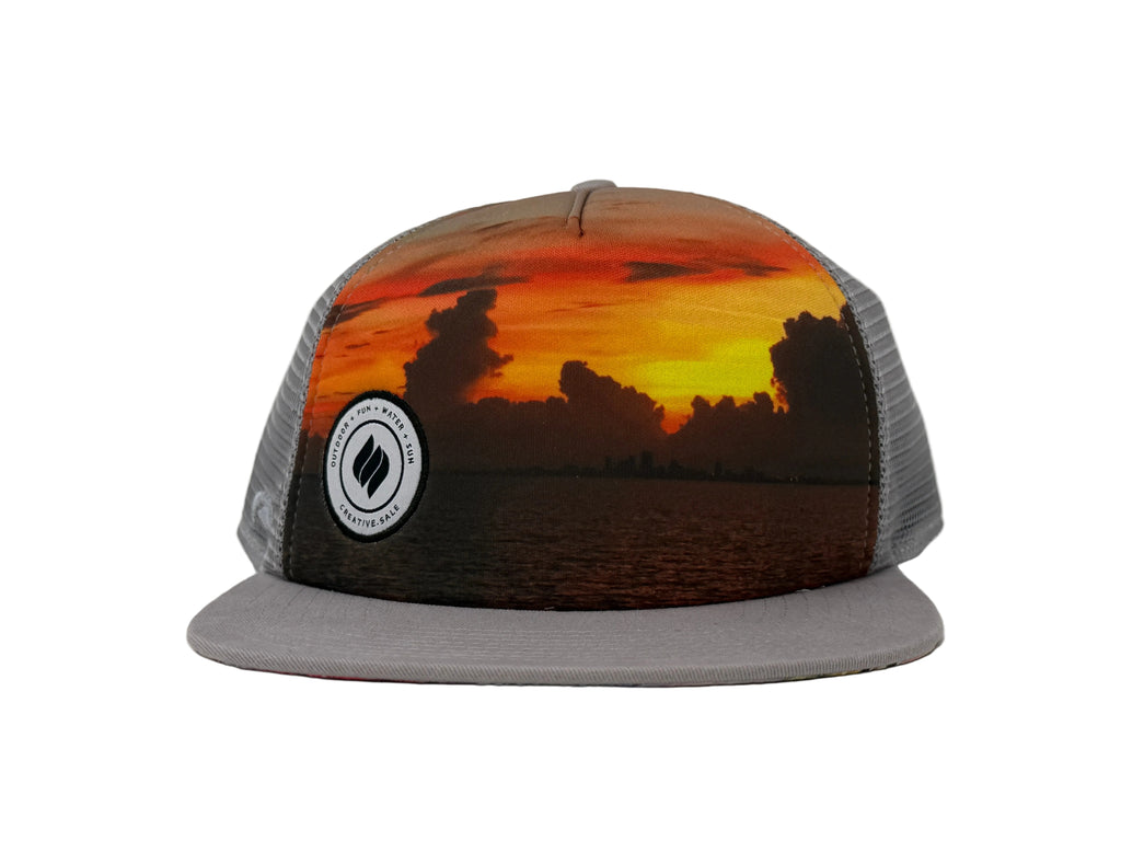 Trucker hat with sunset design and logo on a gray background